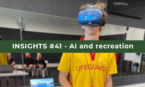 teenage boy in a yellow lifeguard shirt wearing a large blue VR headset