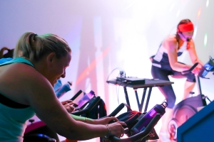 A group of women participate in a spin class