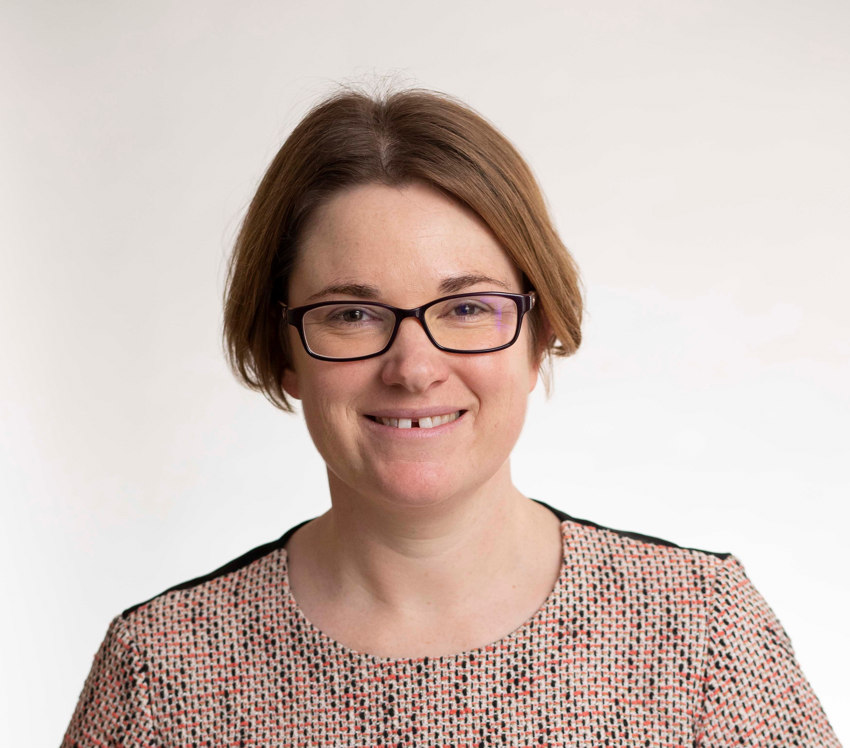 Sarah Murray portrait smiling in brown top