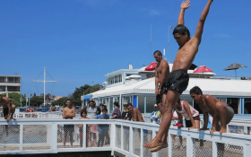 Maori boy diving feet first into the Wellington Harbour