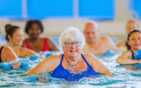 A group of people are in a pool doing an aqua class